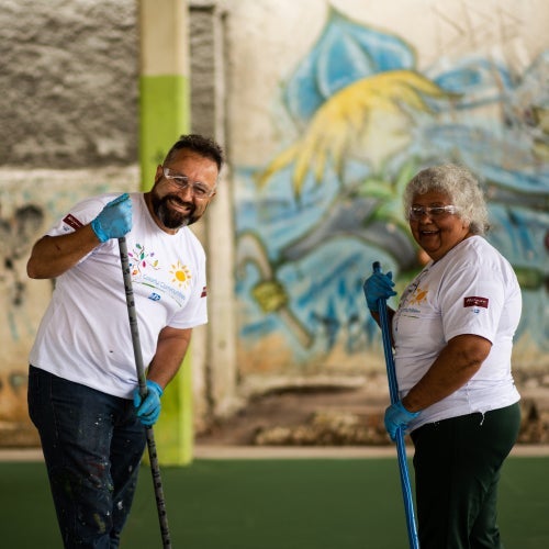 two volunteers with brooms 