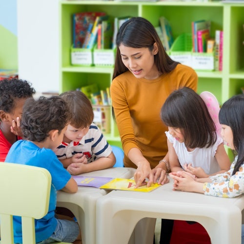 teacher in classroom instructing kids 