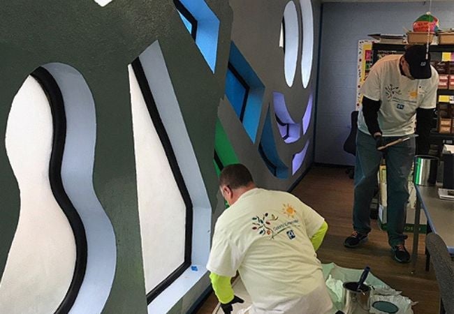 volunteers painting around windows