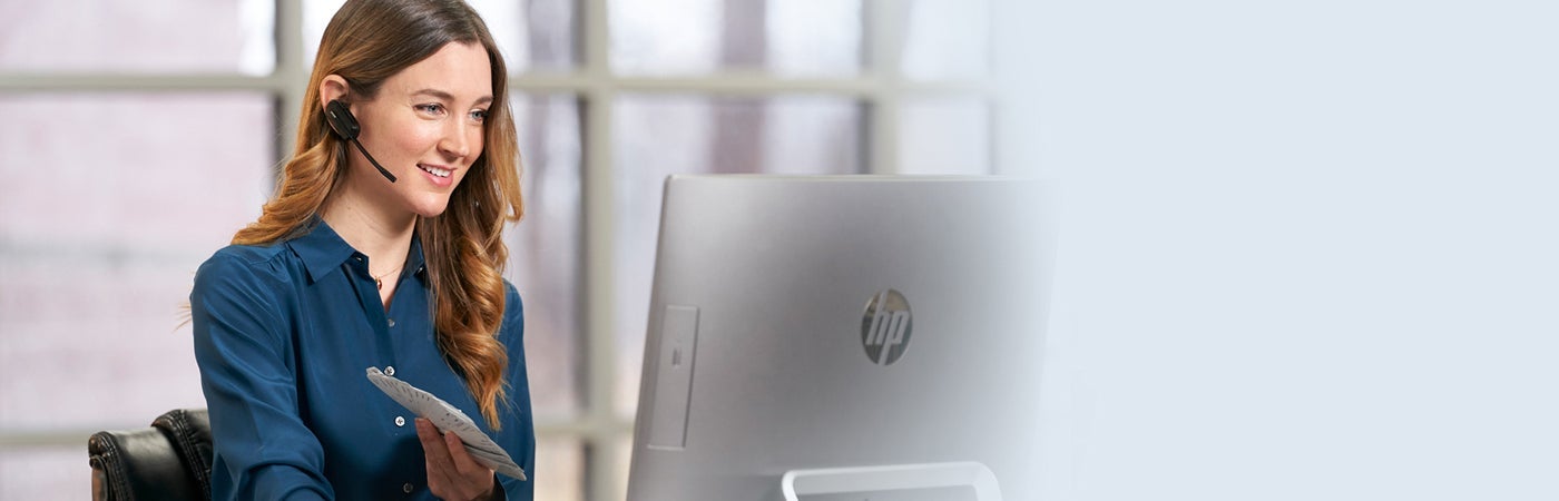 Female employee providing support next to computer