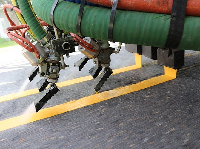 Truck applying paint to roadway