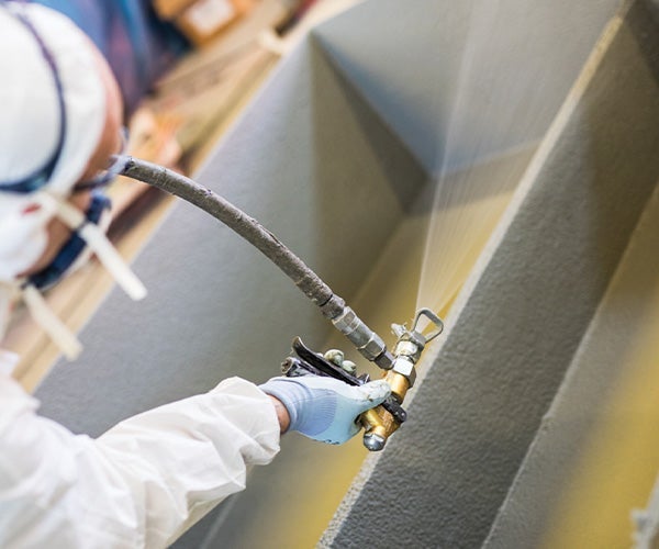 A person spraying a metal pipe