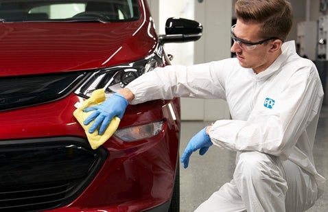 PPG worker polishing red car bodywork