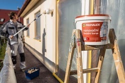 Muž malující dům