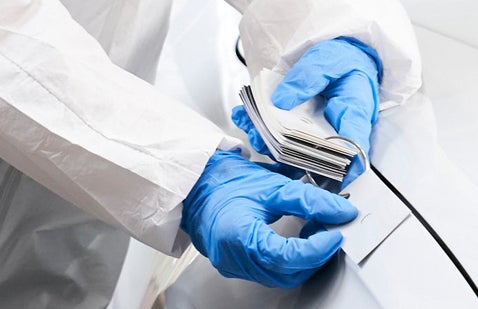 Worker wearing gloves comparing paint swatches