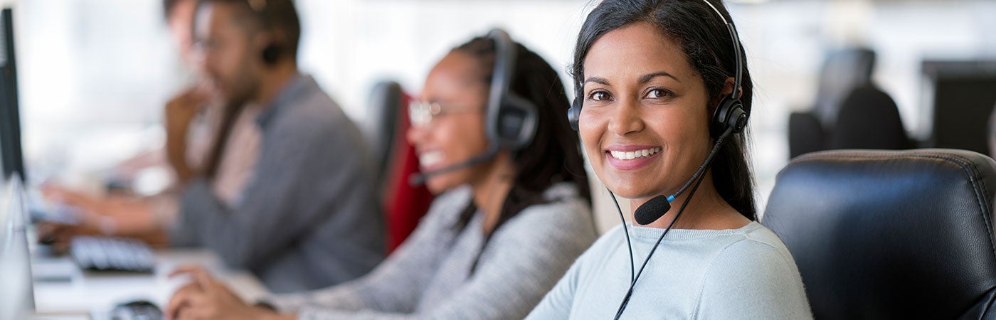 Female office worker using computer with headset