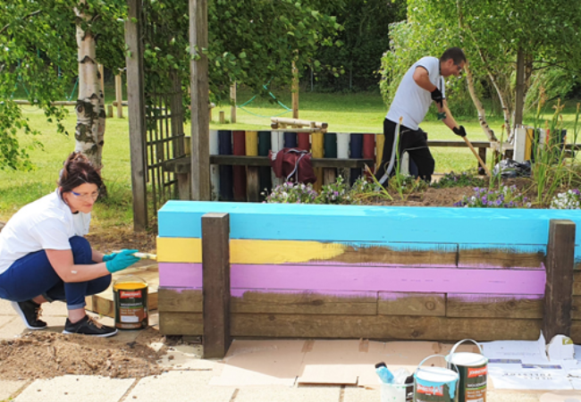 people painting outdoor wall