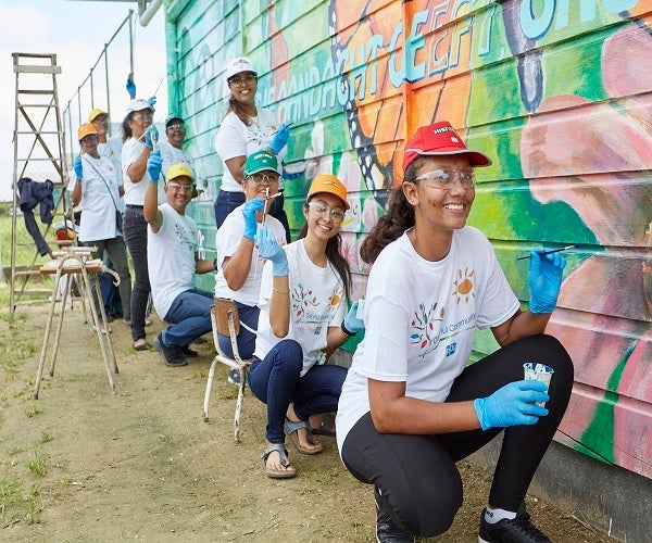 volunteers painting wall mural