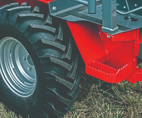 Close up of a black wheel on a red machinery equipment body