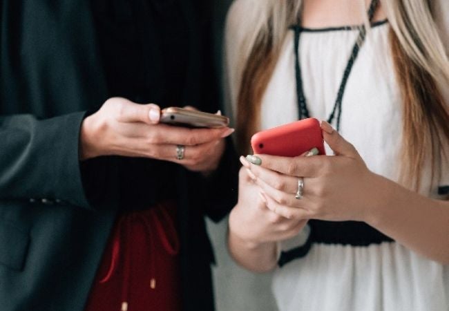 Frauen, die Mobiltelefone in der Hand halten 