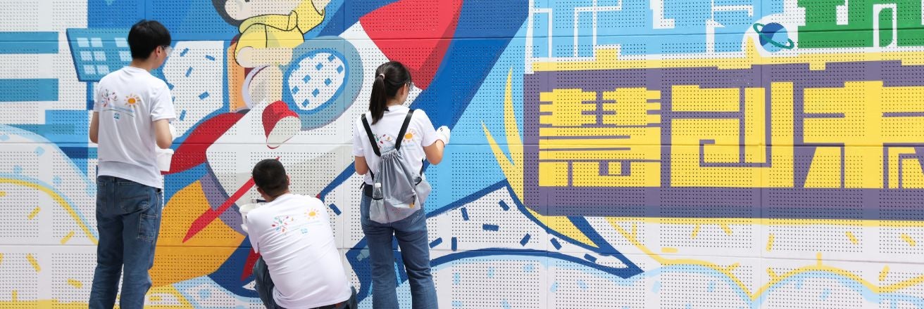 PPG employee volunteers painting mural