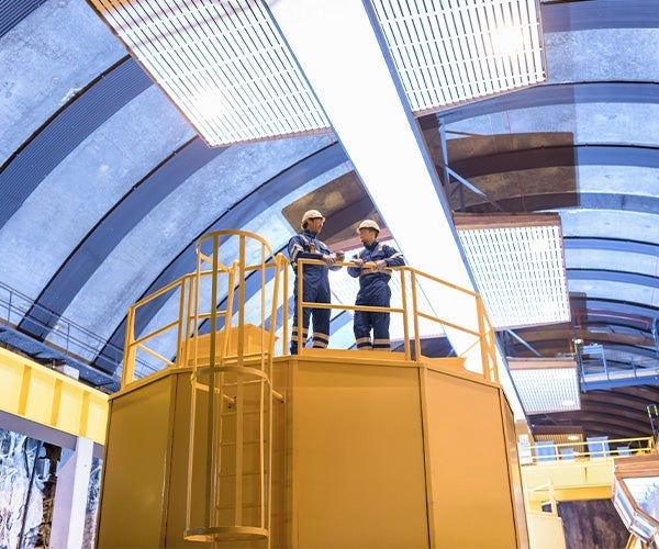 A group of men in hard hats standing on a yellow platform