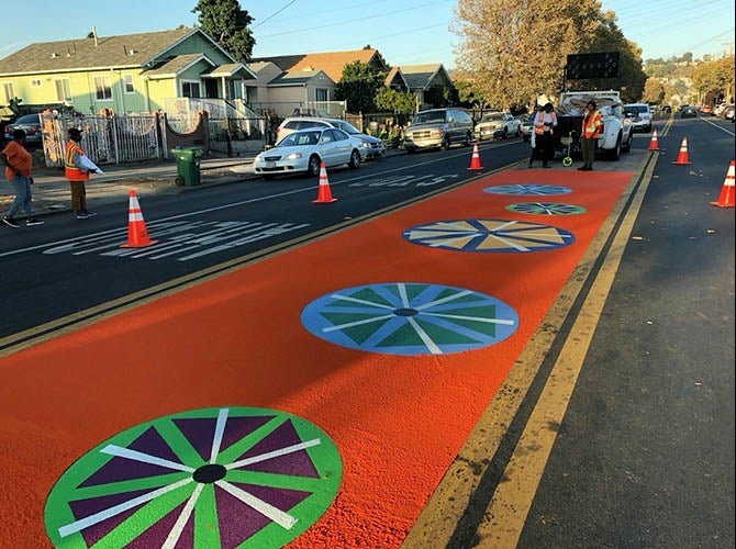 Workers applying markings to create a bike lane in Oakland, CA