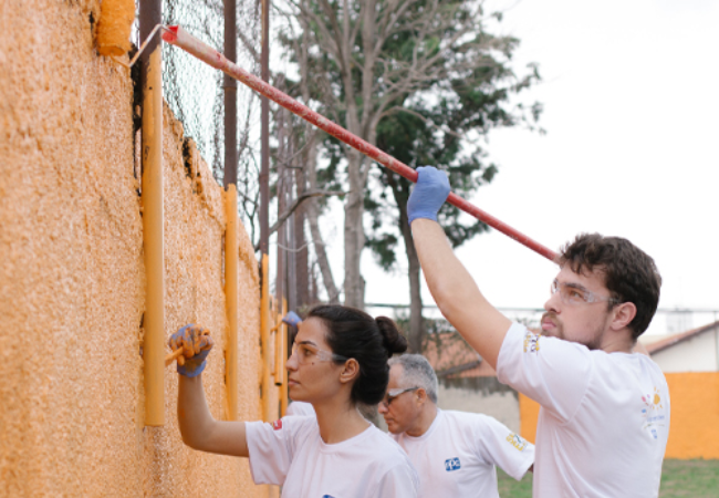 People painting a wall yellow