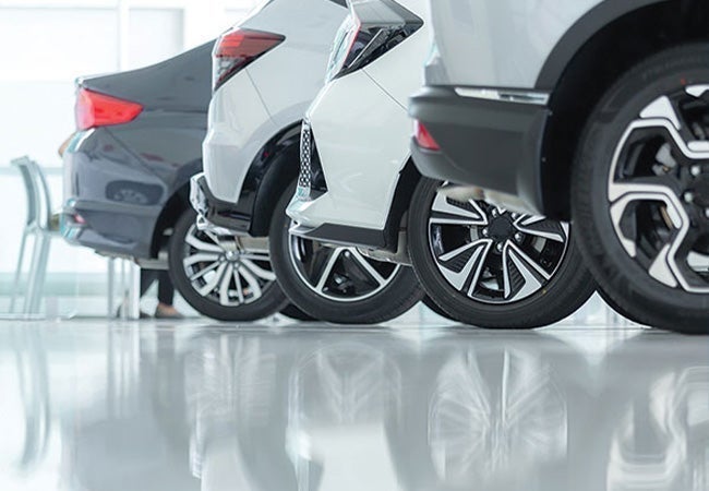 A row of cars parked in a showroom