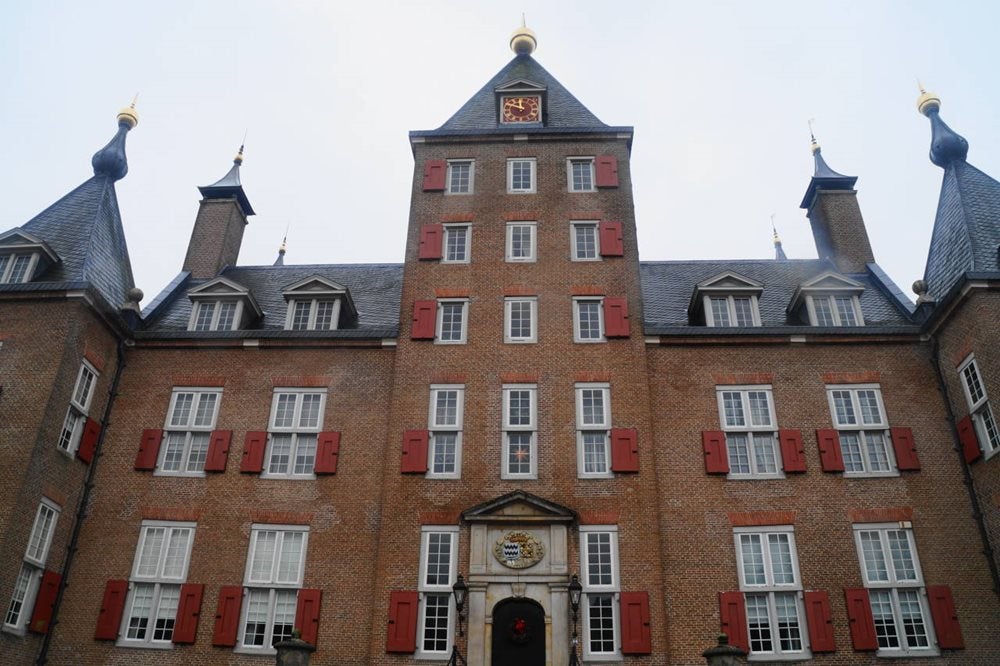 Een groot bakstenen gebouw met een klok erop