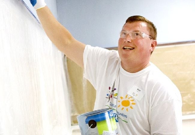 volunteer painting wall blue 