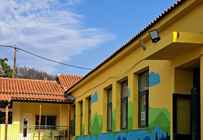 School painted yellow with mountain scene 