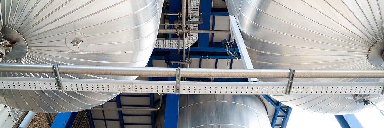 Close-up of the underside of large tanks within manufacturing plant