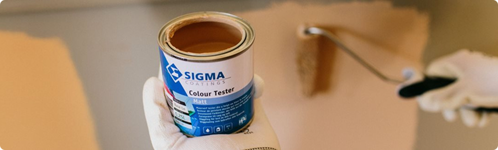 Een hand die een verfblik vasthoudt