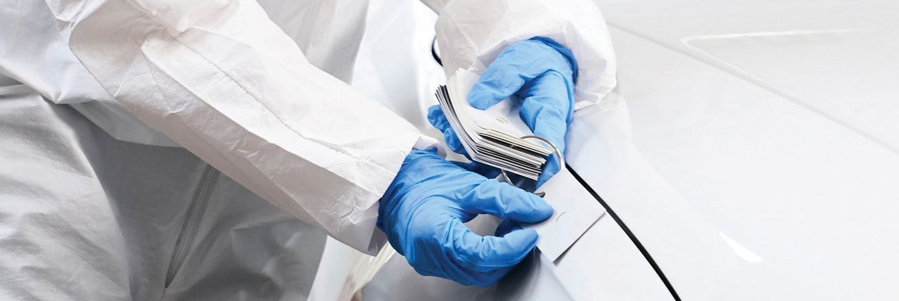 Worker wearing gloves comparing paint swatches