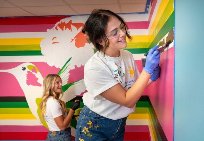 volunteer painting colorful wall