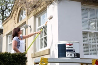 A woman painting a house
