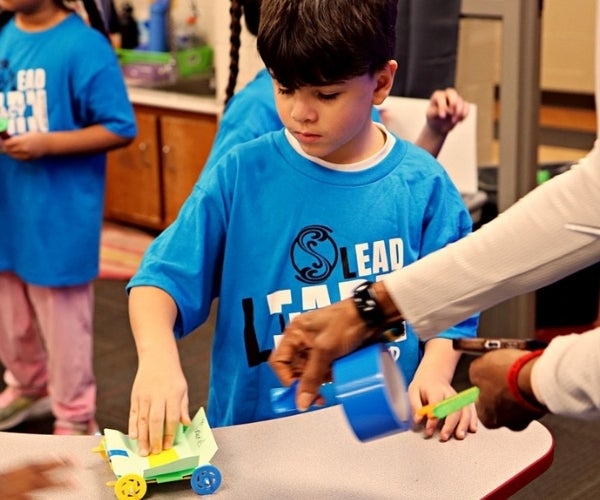 A young boy playing with a toy car