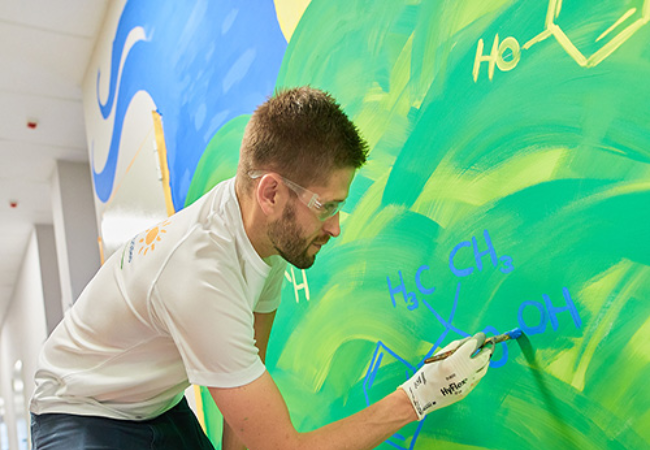 Man painting mural on wall 