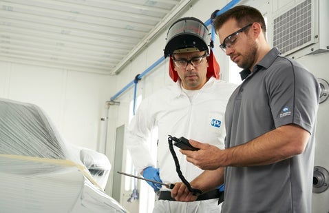 Two male PPG workers discussing readings on equipment