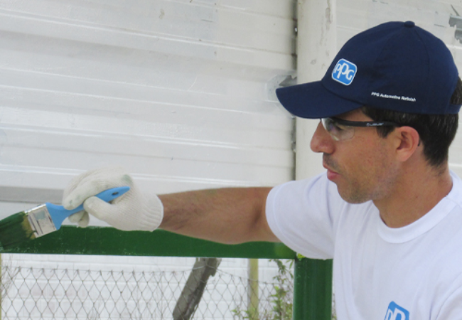 PPG volunteer painting green fence 