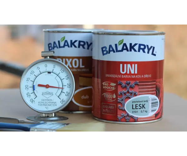 Pár plechoviek farby vedľa meradla