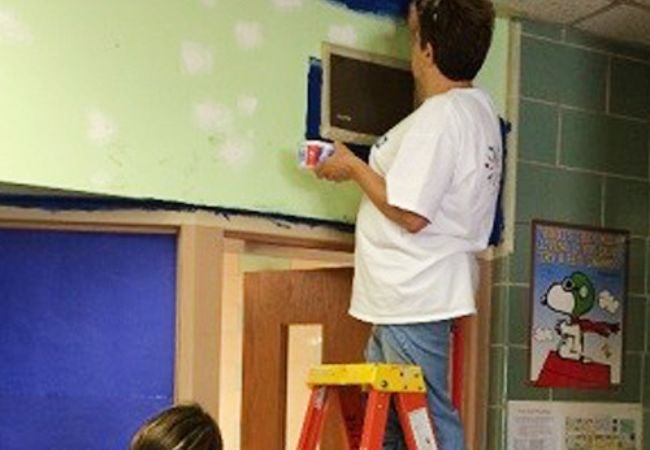 woman painting on ladder