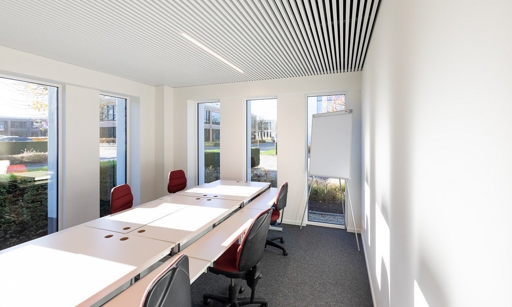 Een kamer met witte tafels en stoelen