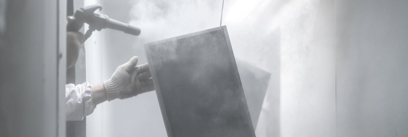 Metal part being sprayed with white powder coating