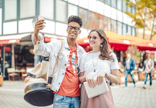 a couple standing in the street taking a selfie