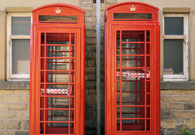 two red phone booths next to each other 