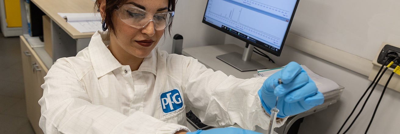 Female PPG worker wearing PPE working with lab equipment