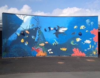 A mural of a sea life with a shark and colorful fish