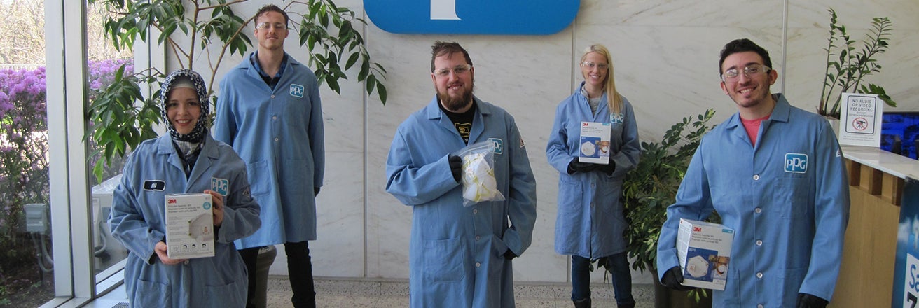 group of PPG workers holding covid test kits 