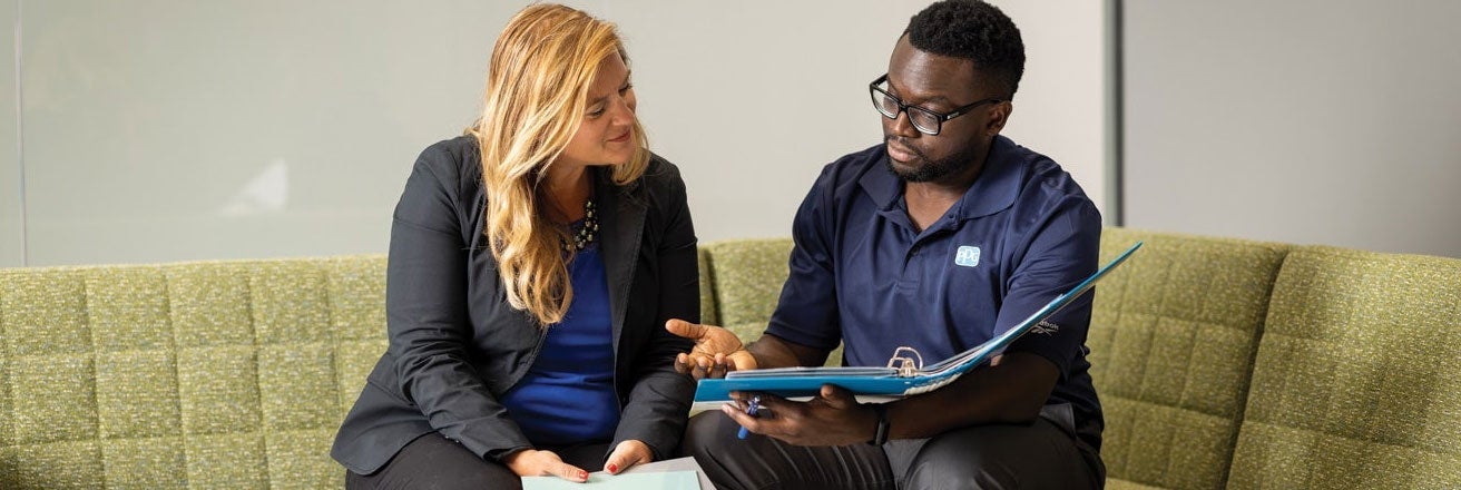 Two PPG employees discussing documents within a folder