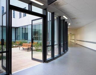 Hospital hallway opening into a seating area with benches.