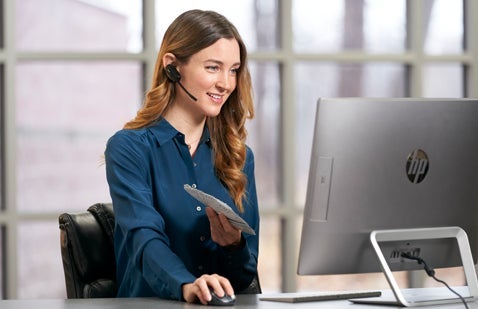 Female employee providing support next to computer