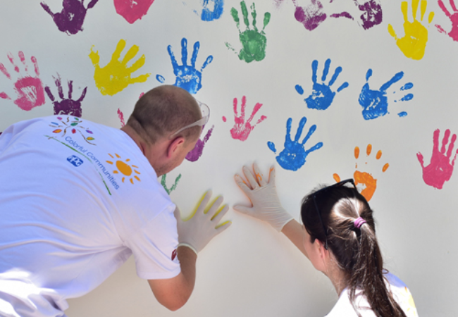 People putting their handprint on a wall with paint in Gravatai, Brazil 