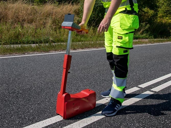 Worker measuring retroreflectivity