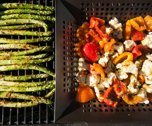 Metal grills cooking asparagus and mixed vegetables