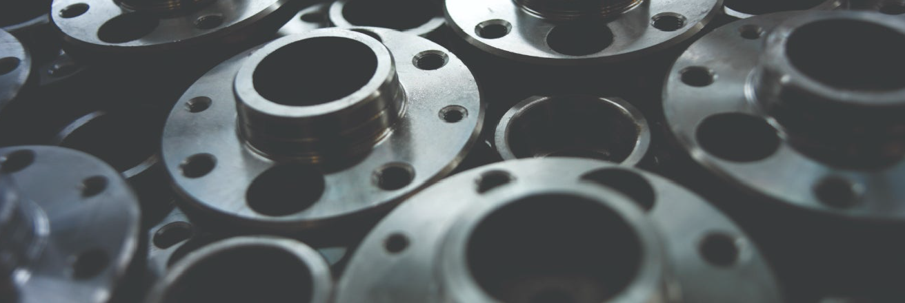 Close-up of stacked metal flanges with circular openings and bolt holes.