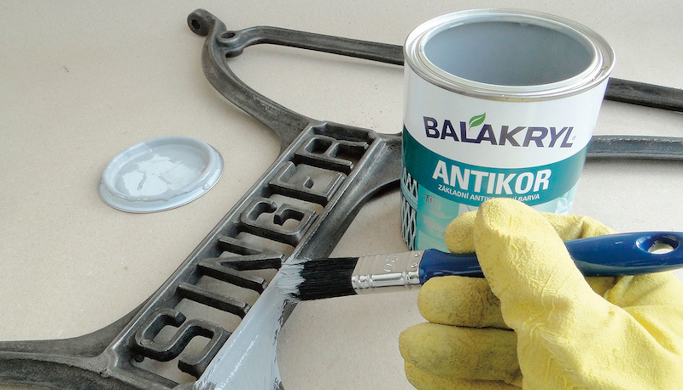 Člověk, který maluje ceduli pomocí plechovky s barvou