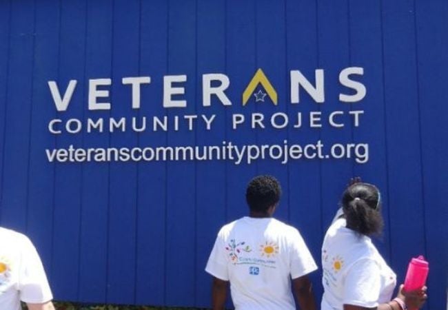 Volunteers painting exterior wall