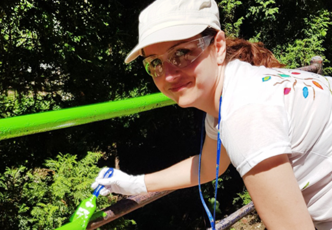 girl painting railing green in Gilwice, Poland 